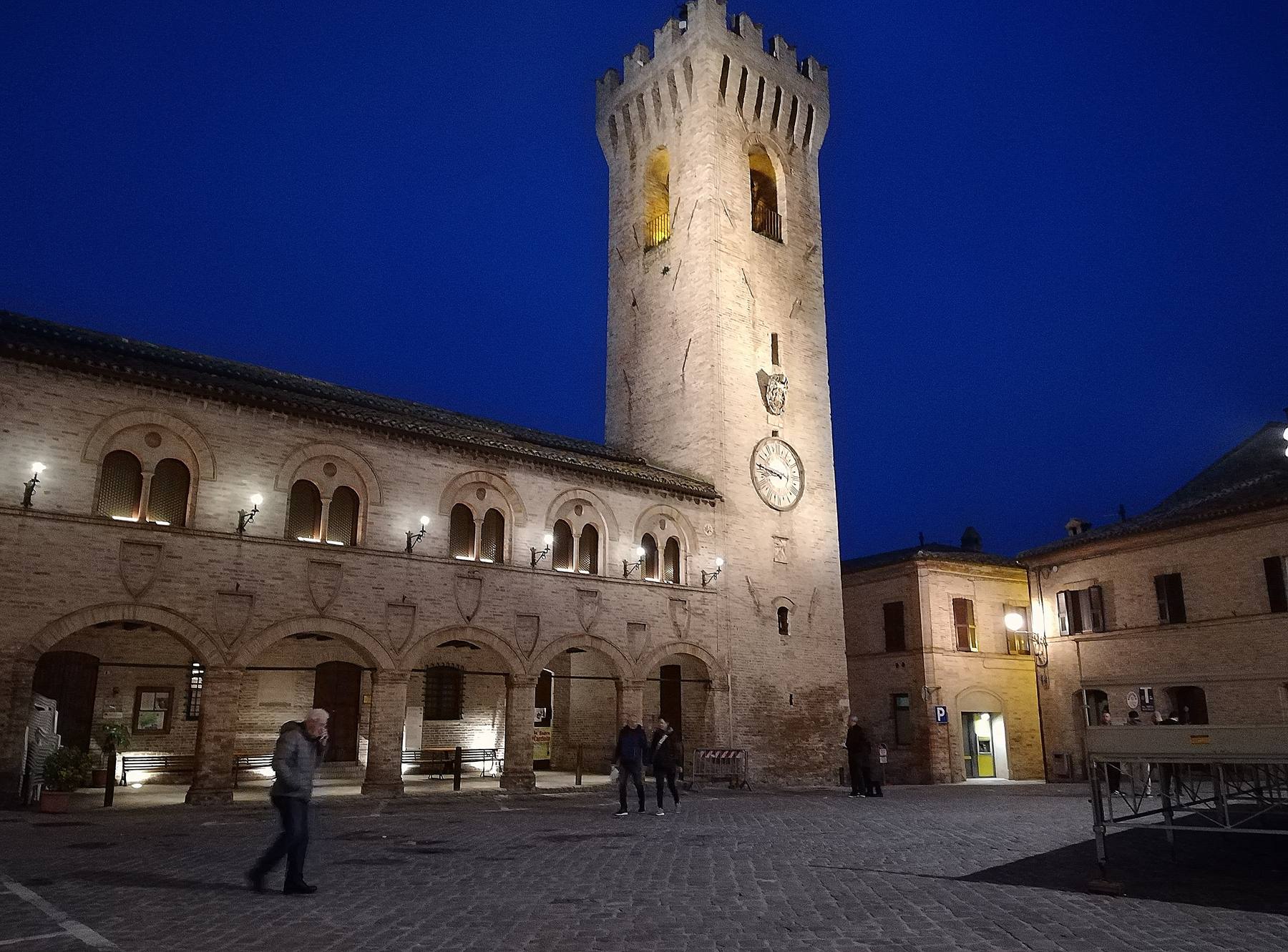 La Torre civica illuminata e la loggia del Palazzetto dei Priori in Piazza del Comune, in bianco e nero